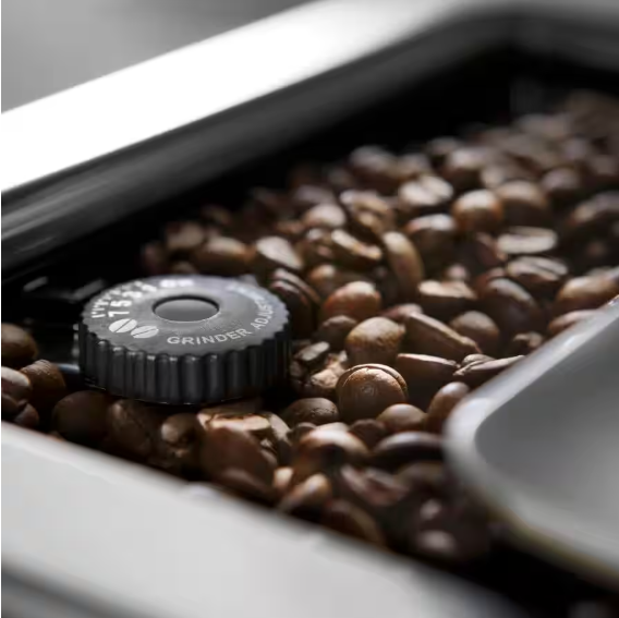 Detailaufnahme des Bohnenbehälters mit frischen Kaffeebohnen und einstellbarem Mahlwerk