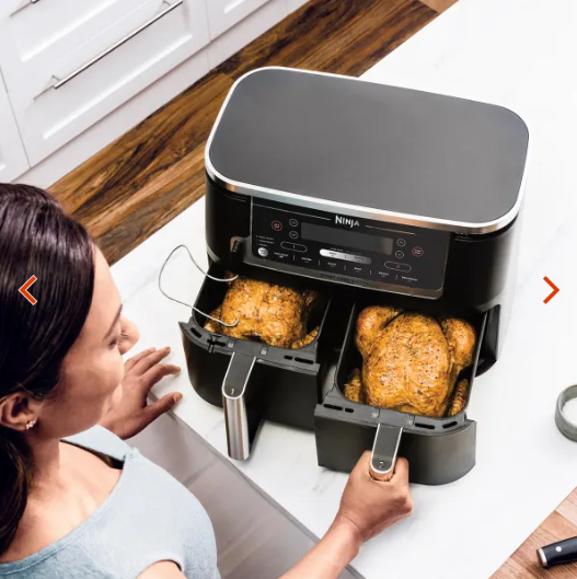 Zwei Hähnchenschenkel werden in die Frittierkörbe eines Ninja Airfryers gelegt
